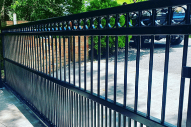 Black metal fence gate with decorative circular emblems