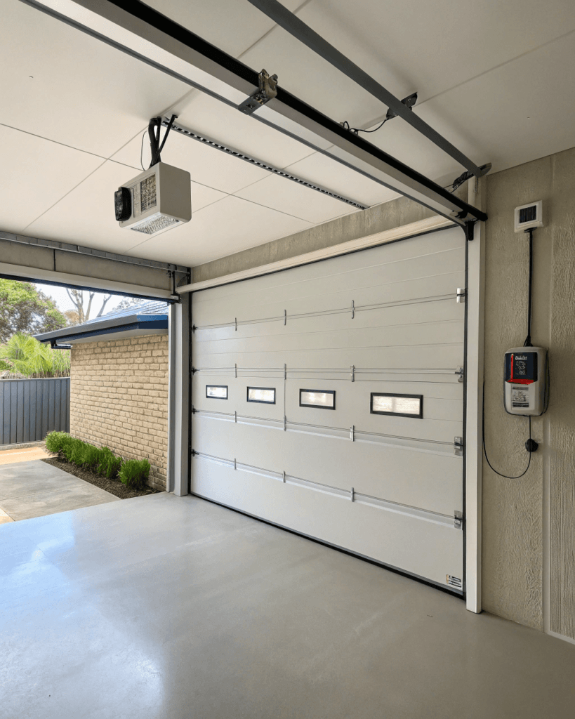 Garage interior showing a hardwired electrical connection point beside the garage door motor