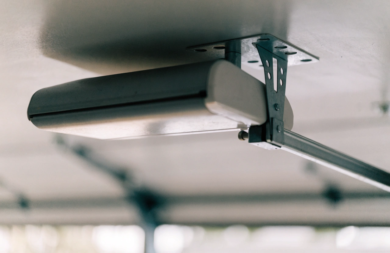 Close-up of a chain-drive garage door opener motor mounted to the ceiling