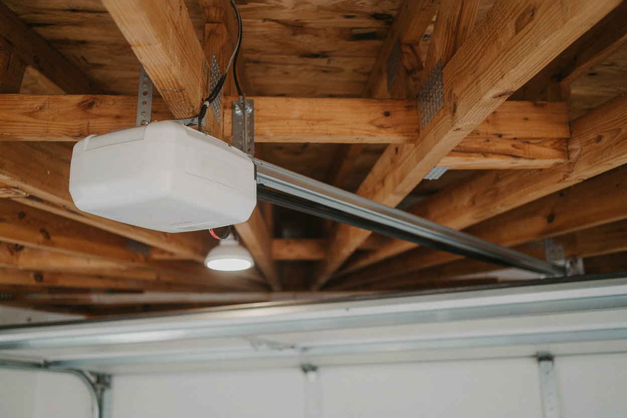 Ceiling view of a garage door opener unit installed in a timber-framed garage